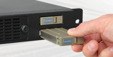 A hand removing a TranzPak 1 rugged storage drive from the ZX1C airborne server